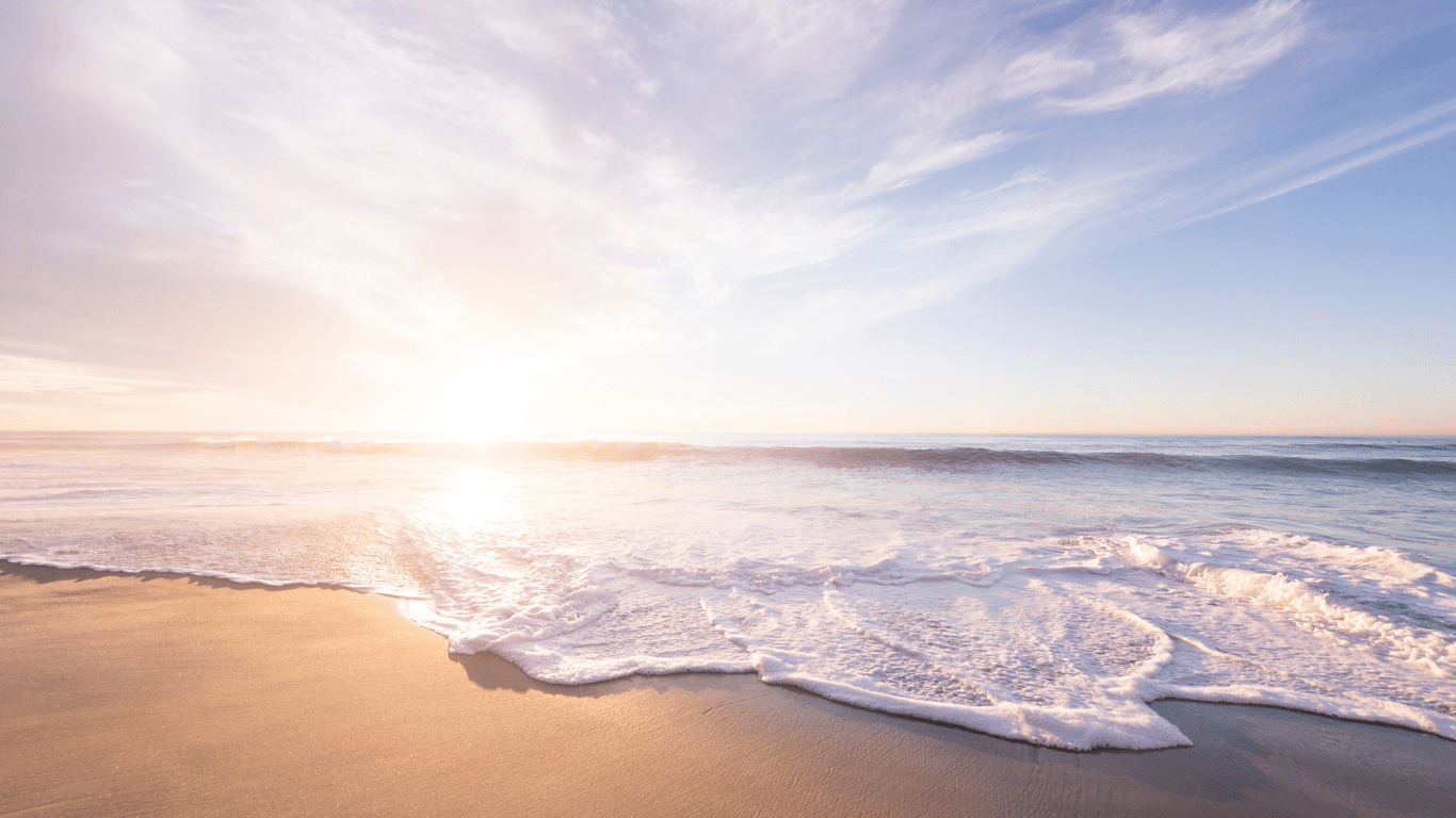 An image of the sun setting over a beach at sundown