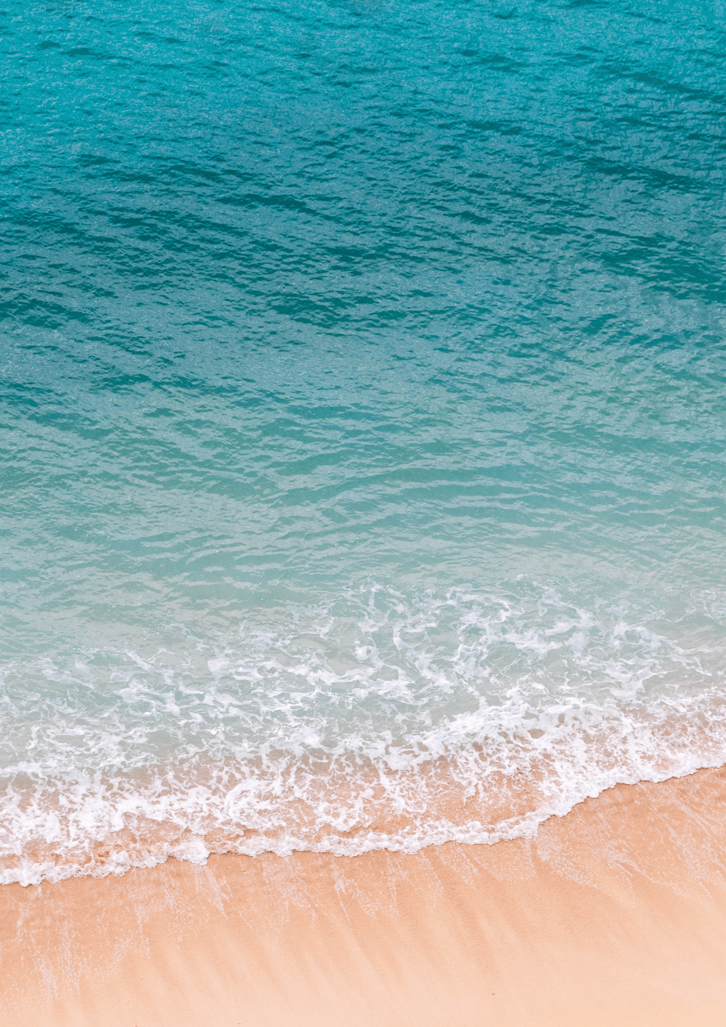 A sideways shot of waves rolling onto the beach.