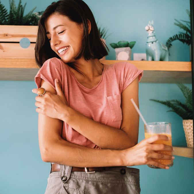 A happy and healthy women holding a nutritious smoothie.